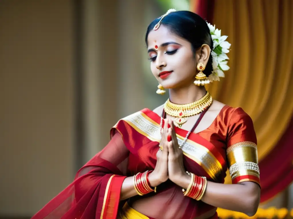 Una bailarina de Odissi con vestuario tradicional rojo y dorado, joyería plateada y expresión serena, iluminada por un foco en el escenario